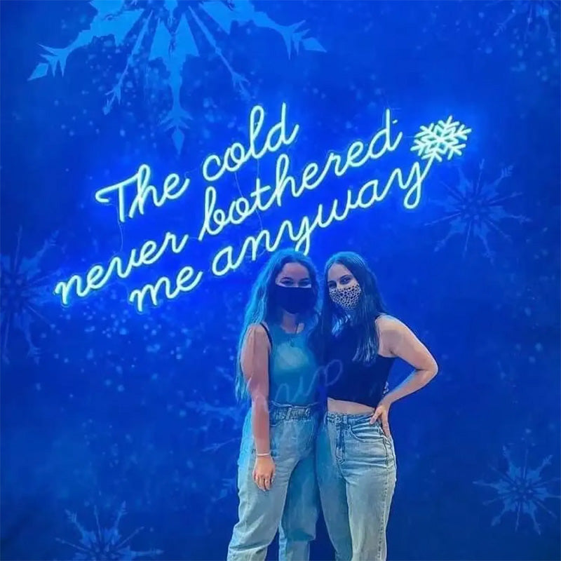 “The Cold Never Bothered Me Anyways” Neon Sign – Blue Script LED Neon Quote with Snowflake Accent