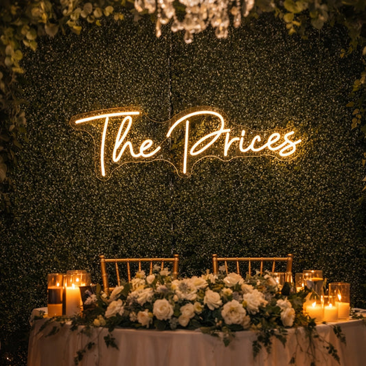 “The Prices” Neon Sign – Warm White Script LED Sign on Greenery Wall Backdrop for Weddings, Engagements, Events & Elegant Photo Booth Decor